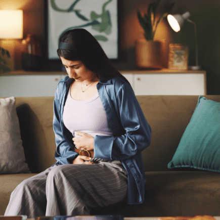 Femme ressentant une douleur abdominale liée à un cycle menstruel irrégulier ou à des règles douloureuses