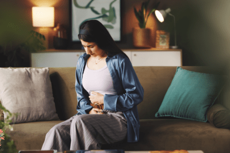 Femme ressentant une douleur abdominale liée à un cycle menstruel irrégulier ou à des règles douloureuses