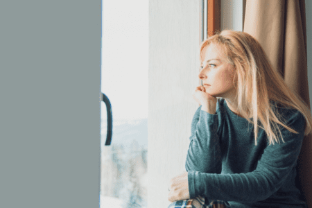 Femme pensive illustrant l’incompréhension face aux fringales et au stockage liés à une glycémie instable