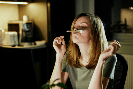 Femme fatiguée tenant un stylo, illustrant la charge mentale, le stress chronique et leurs effets sur la glycémie et l’insuline