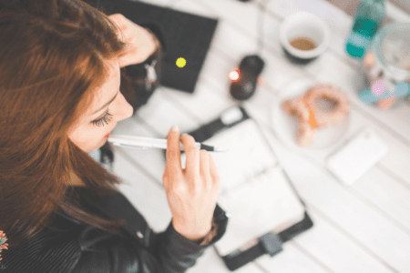 Femme qui observe son cycle en écrivant dans un carnet pour mieux comprendre son ovulation et sa fertilité.