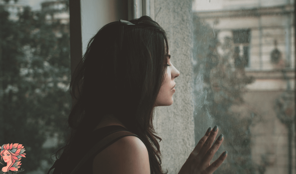 Femme fatiguée regardant par la fenêtre, illustrant les pics de glycémie et la fatigue après les repas