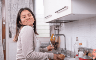 Femme sereine en cuisine illustrant une approche douce pour stabiliser la glycémie et perdre du poids