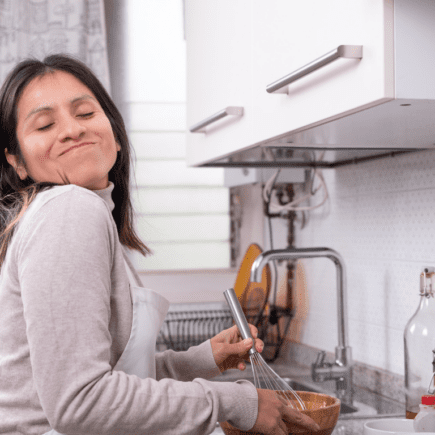 Femme sereine en cuisine illustrant une approche douce pour stabiliser la glycémie et perdre du poids