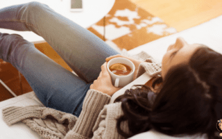 Femme se reposant avec une boisson chaude illustrant l’impact du cycle menstruel sur la glycémie et les hormones